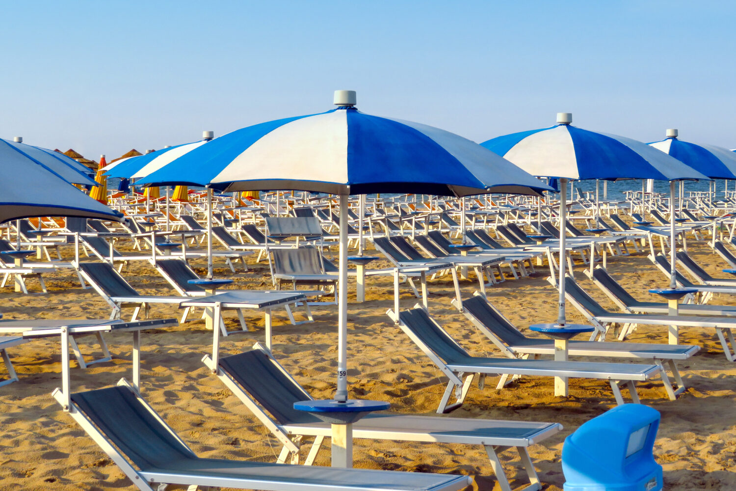 Sdrai blu e ombrelloni a spicchi bianchi e blu sulla spiaggia di Caorle