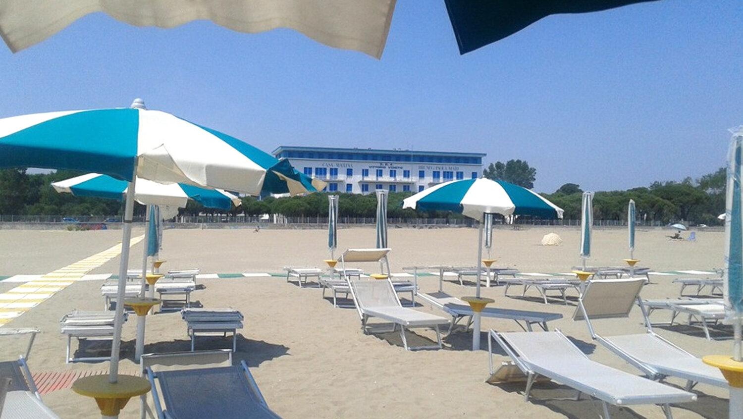 Foto della Casa Marina vista dagli ombrelloni della spiaggia di fronte